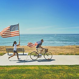 Junge Leute mit amerikanischer Flagge am Strand © frank mckenna / unsplash.com
